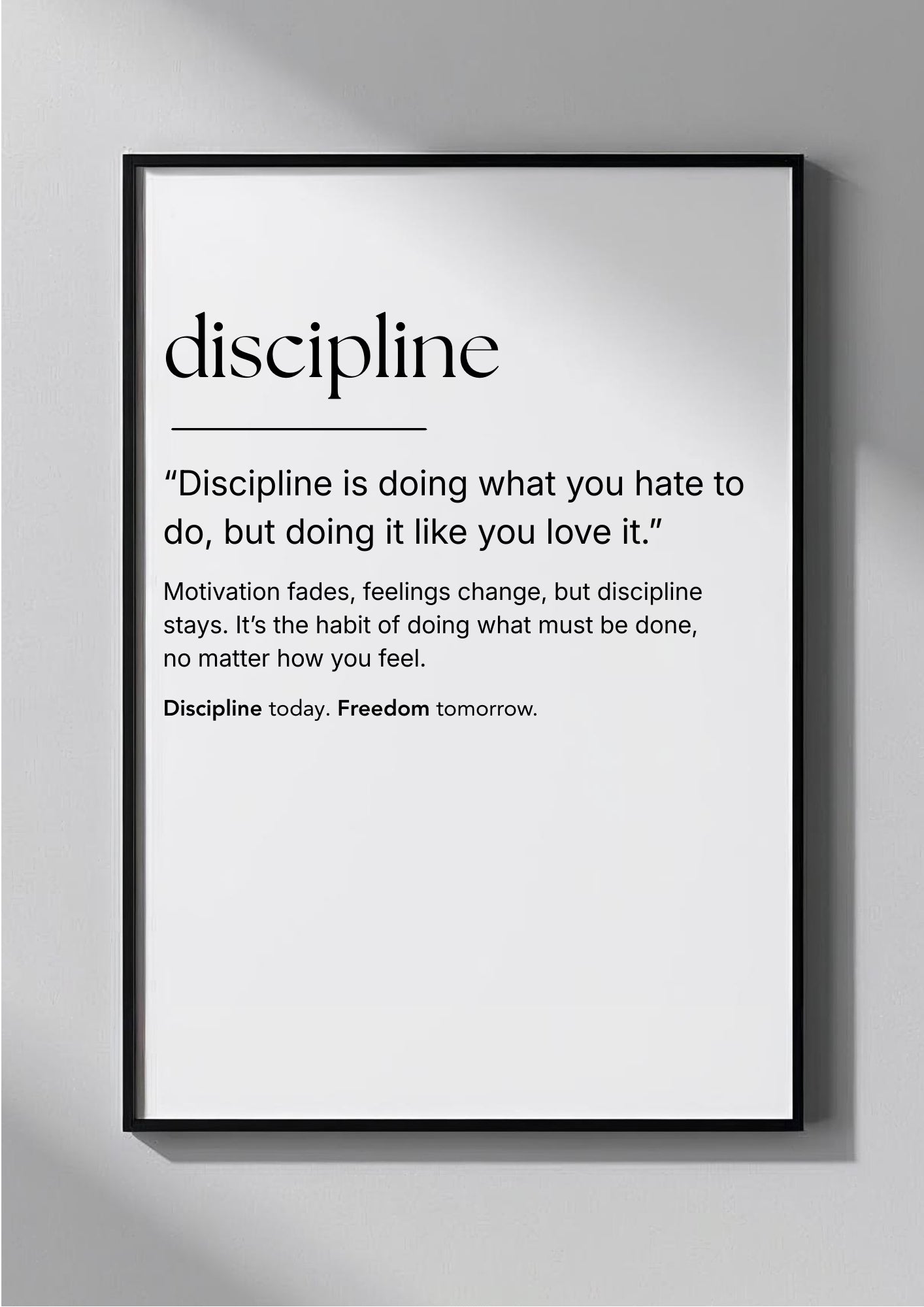 Framed poster with the word 'discipline' and a quote on a gray wall.
