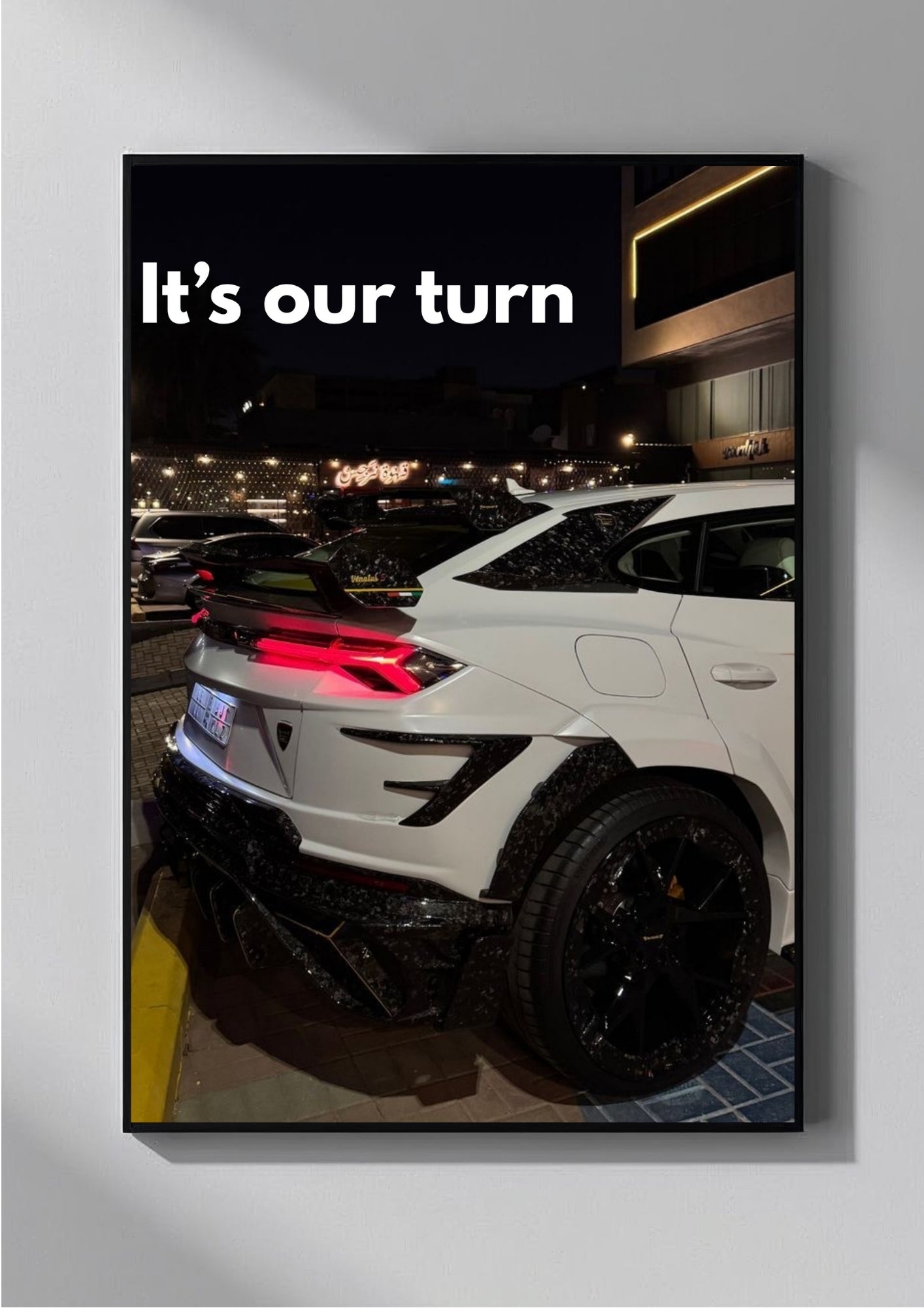 White car with black rims in a parking lot at night, text 'It's our turn' above.