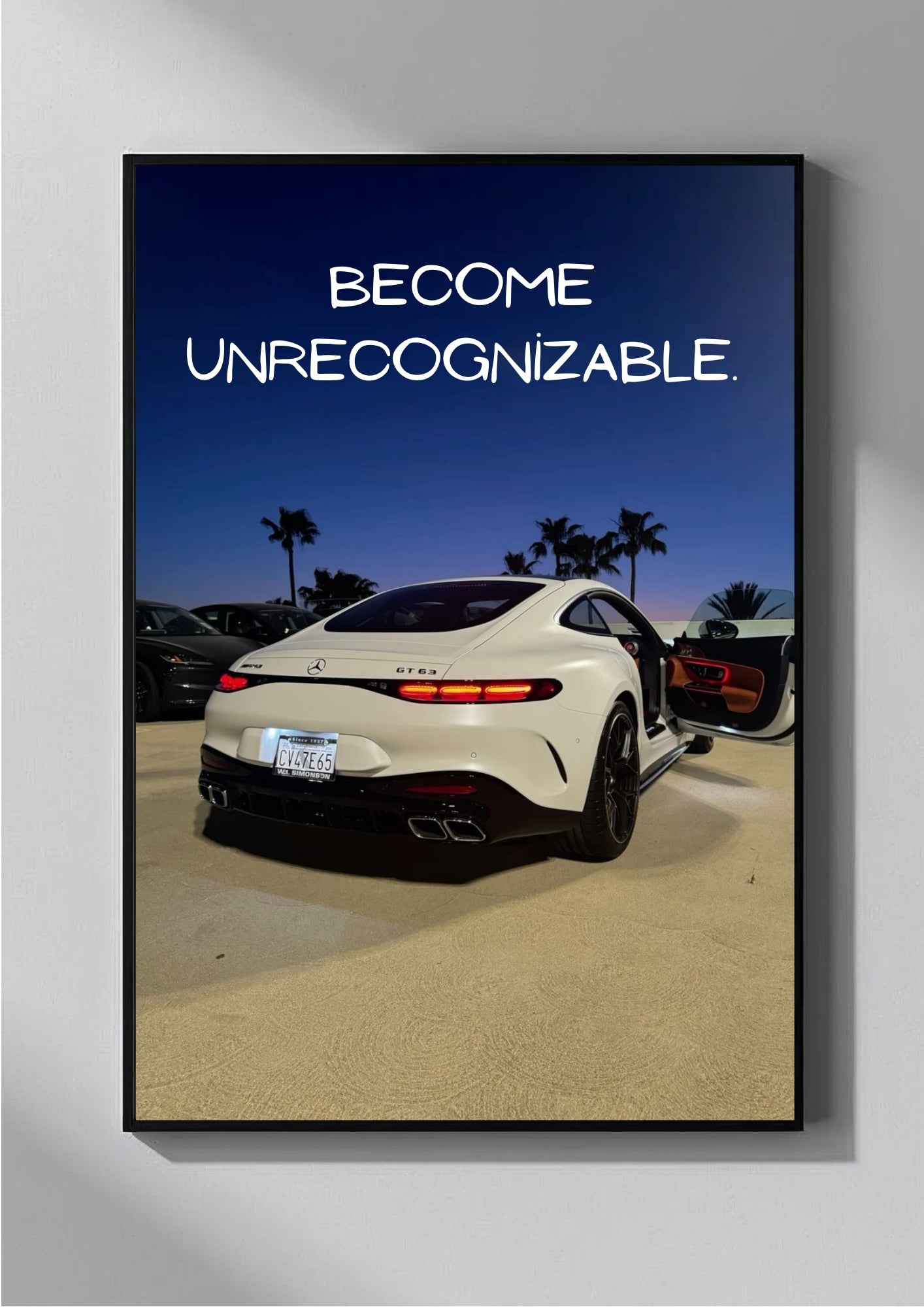 White sports car with 'Become Unrecognizable' text on a framed poster.
